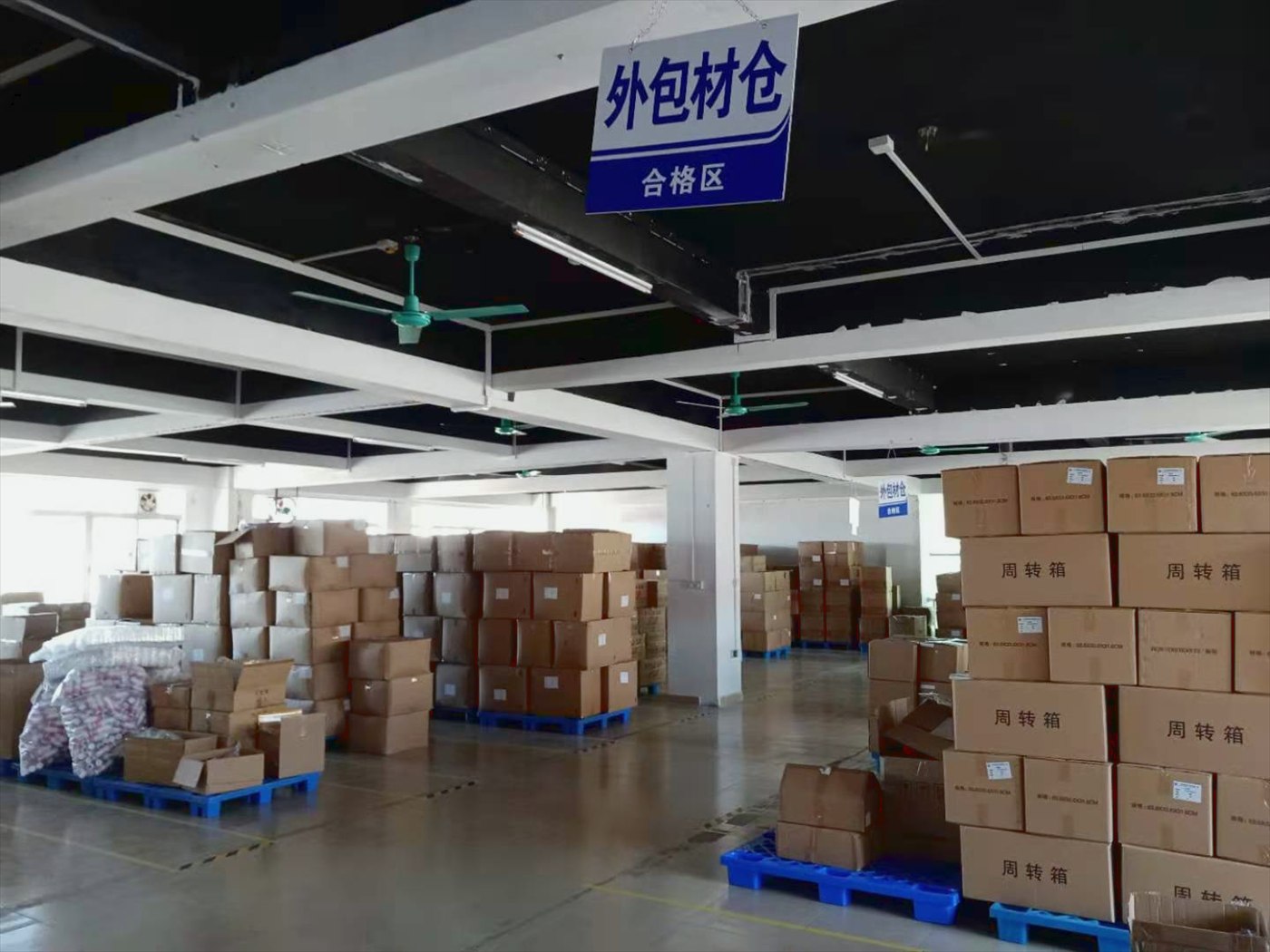 Packaging-materials warehouse with palletised cartons in the qualified-goods zone